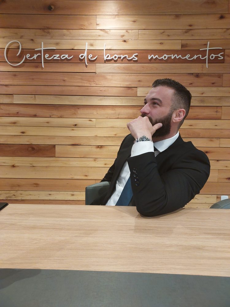 Avimar de terno, sentado e pensativo diante de uma parede de madeira, cinco dias antes da prova oral da PCSC.